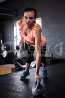 Portrait of sporty young woman holding kettlebell