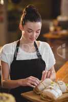 Smiling waitress standing at counter with sandwiches