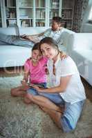 Mother and daughter sitting on floor and using digital tablet