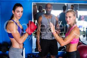 Portrait of serious female boxers by coach