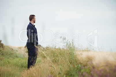 Thoughtful farmer standing in field