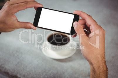Hands taking photograph of coffee