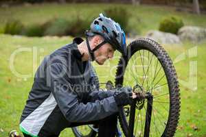 Male cyclist repairing his mountain bike