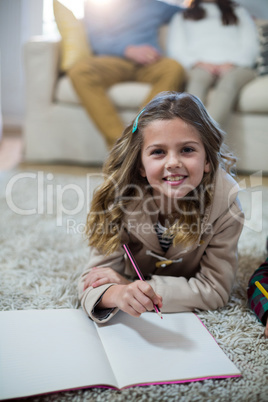 Girl doing homework while lying on the floor