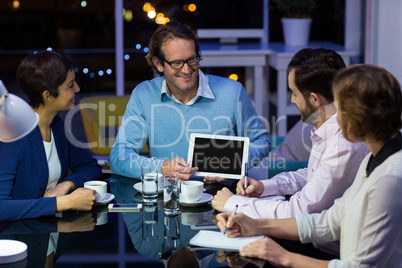 Businessman discussing work on digital tablet with colleagues