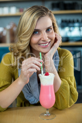 Portrait of woman drinking milkshake with a straw