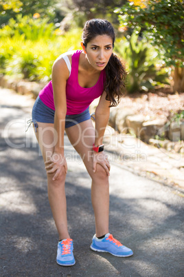 Tired woman taking a break while jogging