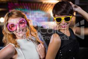 Smiling female friends dancing on dance floor