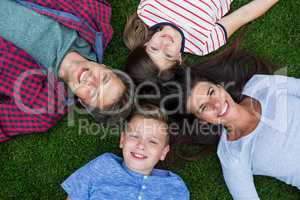 Happy family lying on grass in park on a sunny day