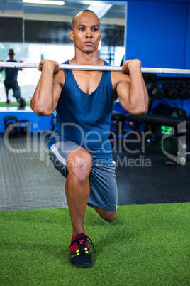 Man lifting barbell in fitness studio