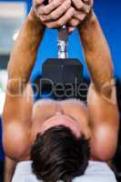 Shirtless athlete exercising with dumbbell