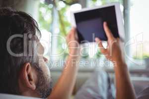 Man using digital tablet in living room