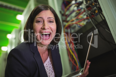 Portrait of happy technician holding laptop
