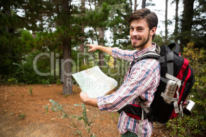 Male hiker holding a map and showing direction