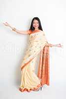 Young woman in Indian sari dress dancing