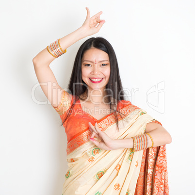 Young girl in Indian sari dress dancing