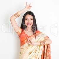 Young girl in Indian sari dress dancing