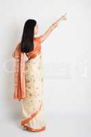 Rear view woman in Indian sari dress pointing