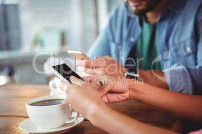 Hands of couple using mobile phone