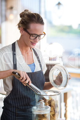 Waitress removing sweet food from tong in cafÃ?Â©