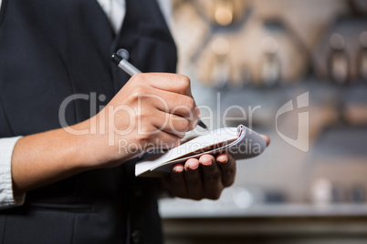 Bartender writing down an order