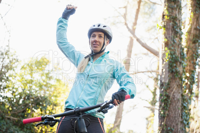 Excited female mountain biker in forest