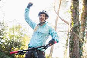 Excited female mountain biker in forest