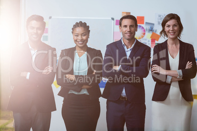 Group of businesspeople with arms crossed standing in front of whiteboard