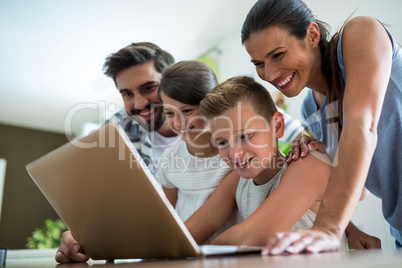 Happy family using laptop in the living room