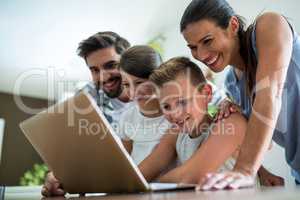 Happy family using laptop in the living room