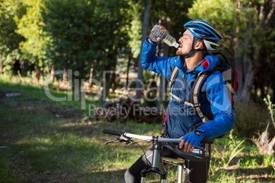 Male mountain biker drinking water