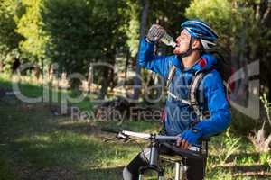 Male mountain biker drinking water