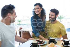 Friends interacting with each other in coffee shop