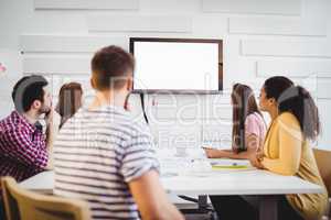 Executives watching at television during training in creative office
