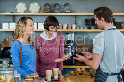 Customer making payment through payment terminal at counter