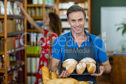 Portrait of male staff holding a tray of bread