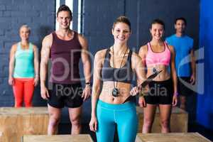 Female trainer with athletes by in fitness studio