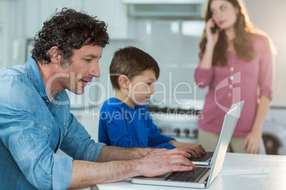 Father and son using laptop