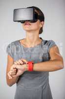 Woman touching smart watch and using virtual reality headset
