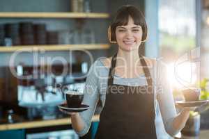 Portrait of waitress holding cup of coffee