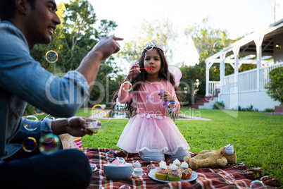 Father and daughter playing with soap bubbles