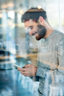 Smiling man using mobile phone