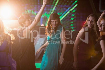 Group of smiling friends dancing on dance floor