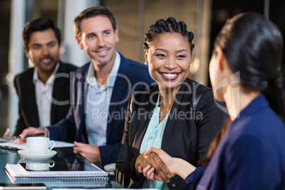 Businesswoman shaking hands with colleague