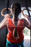 Rear view of young athlete holding gymnastic rings