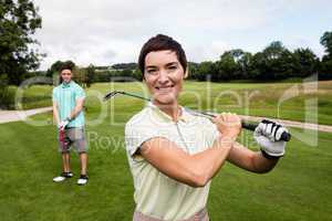 Couple standing with golf club in golf course