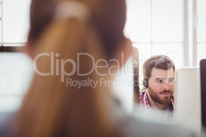 Businessman working with colleague on computer at creative office