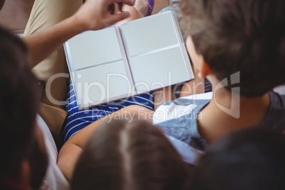 Rear view of siblings looking at a photo album