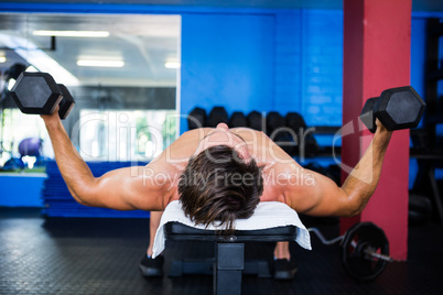 Full length of shirtless man holding dumbbell