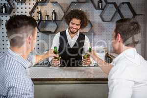 Bartender serving glass of beer to customers
